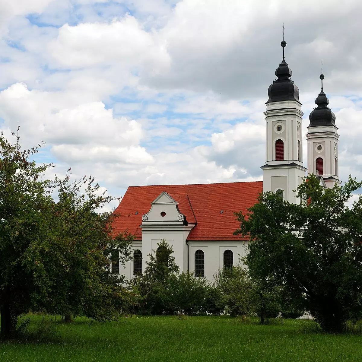 a white church with a red roof and two towers