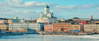 a large white building with a green dome sits in the middle of a city