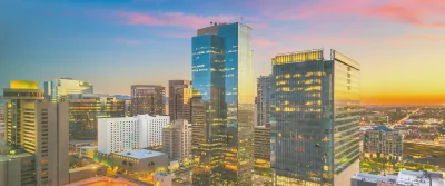 a city skyline with a sunset in the background