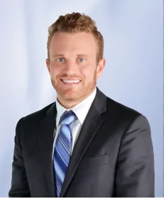 a man in a suit and tie smiles for the camera