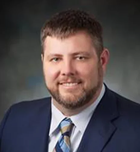 a man in a suit and tie is smiling for the camera .