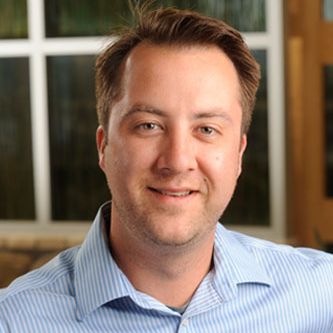 a man in a blue striped shirt is smiling for the camera .