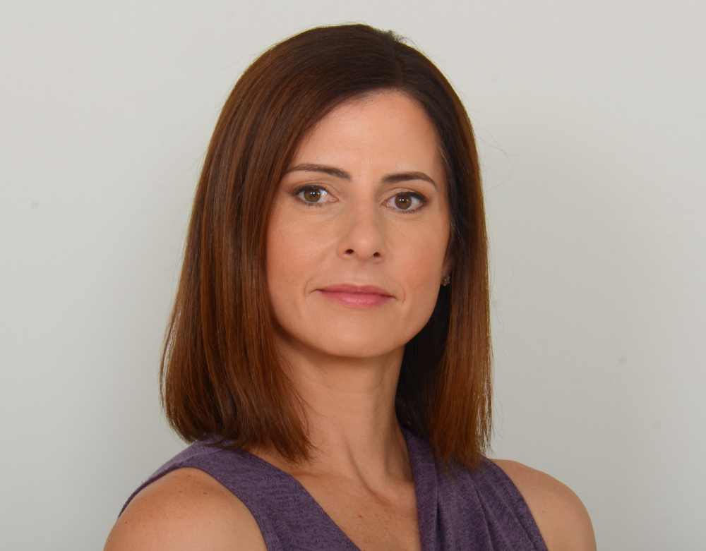 a woman with brown hair is wearing a purple tank top