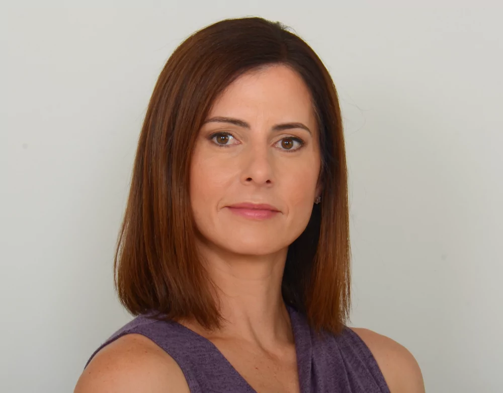 a woman with brown hair is wearing a purple tank top