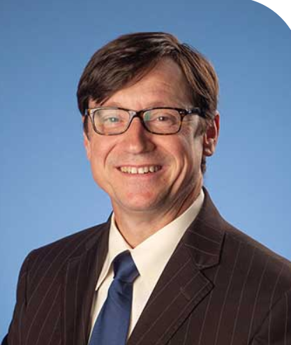a man in a suit and tie is smiling for the camera .