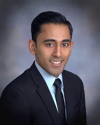 a man in a suit and tie is smiling for the camera .