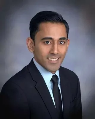a man in a suit and tie is smiling for the camera .