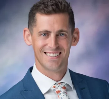 a man in a suit and tie smiles for the camera