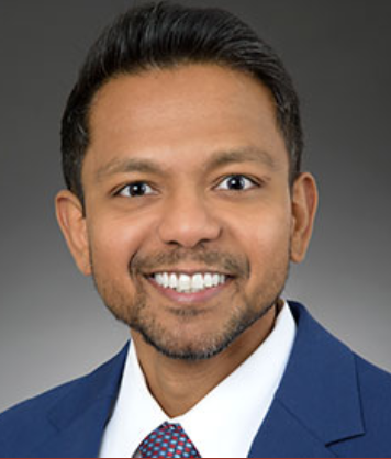 a man in a suit and tie is smiling for the camera