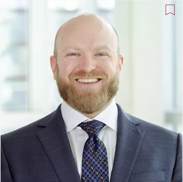 a man in a suit and tie smiles for the camera