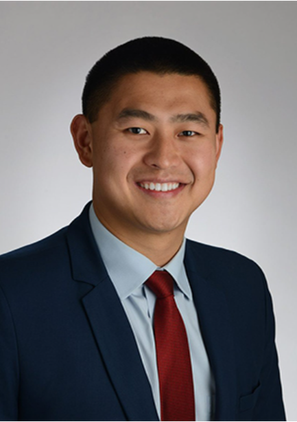 a man in a suit and tie smiles for the camera