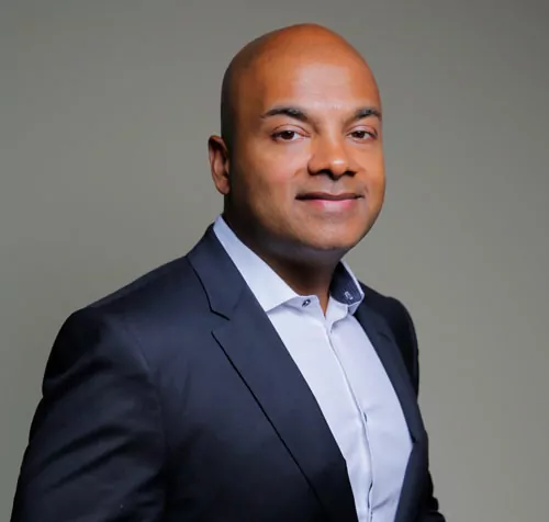 a man in a suit and white shirt smiles for the camera