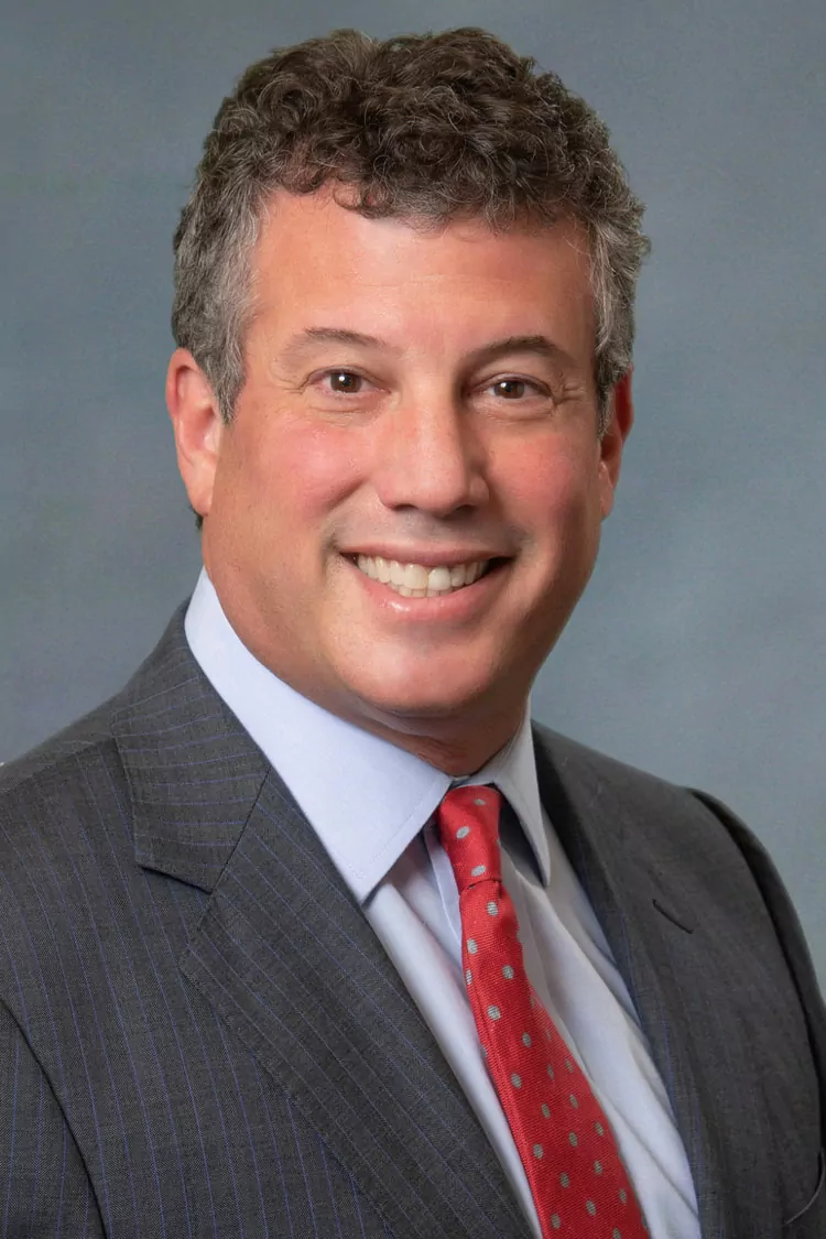 a man in a suit and tie smiles for the camera