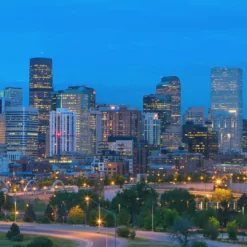 a city skyline at night with a bridge in the foreground