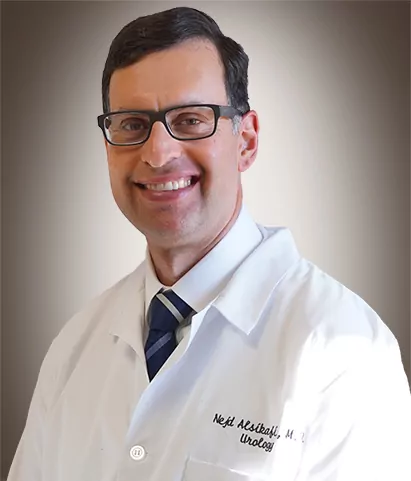 a man wearing glasses and a white coat that says Neil aesibaff m.d. urology