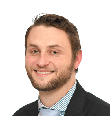 a man with a beard wearing a suit and tie smiles for the camera