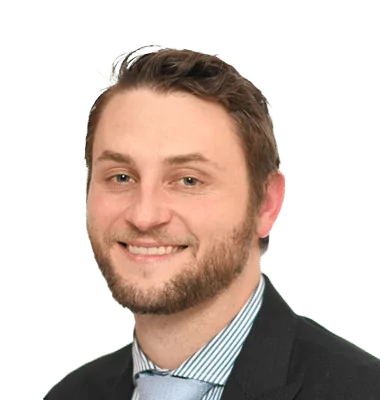 a man with a beard wearing a suit and tie smiles for the camera