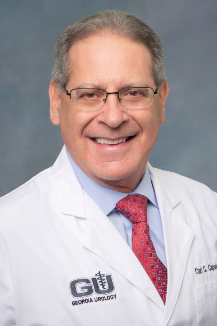 a man wearing glasses and a white coat that says georgia urology