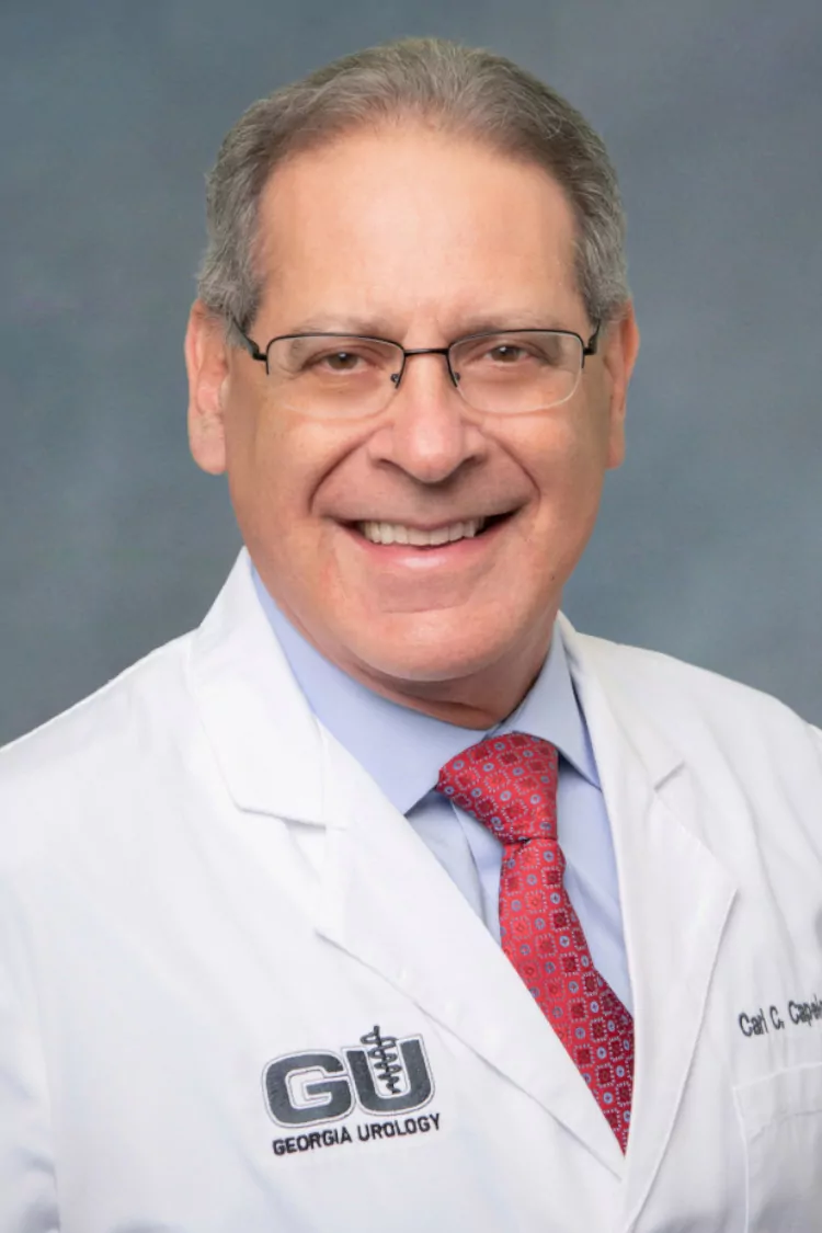 a man wearing glasses and a white coat that says georgia urology
